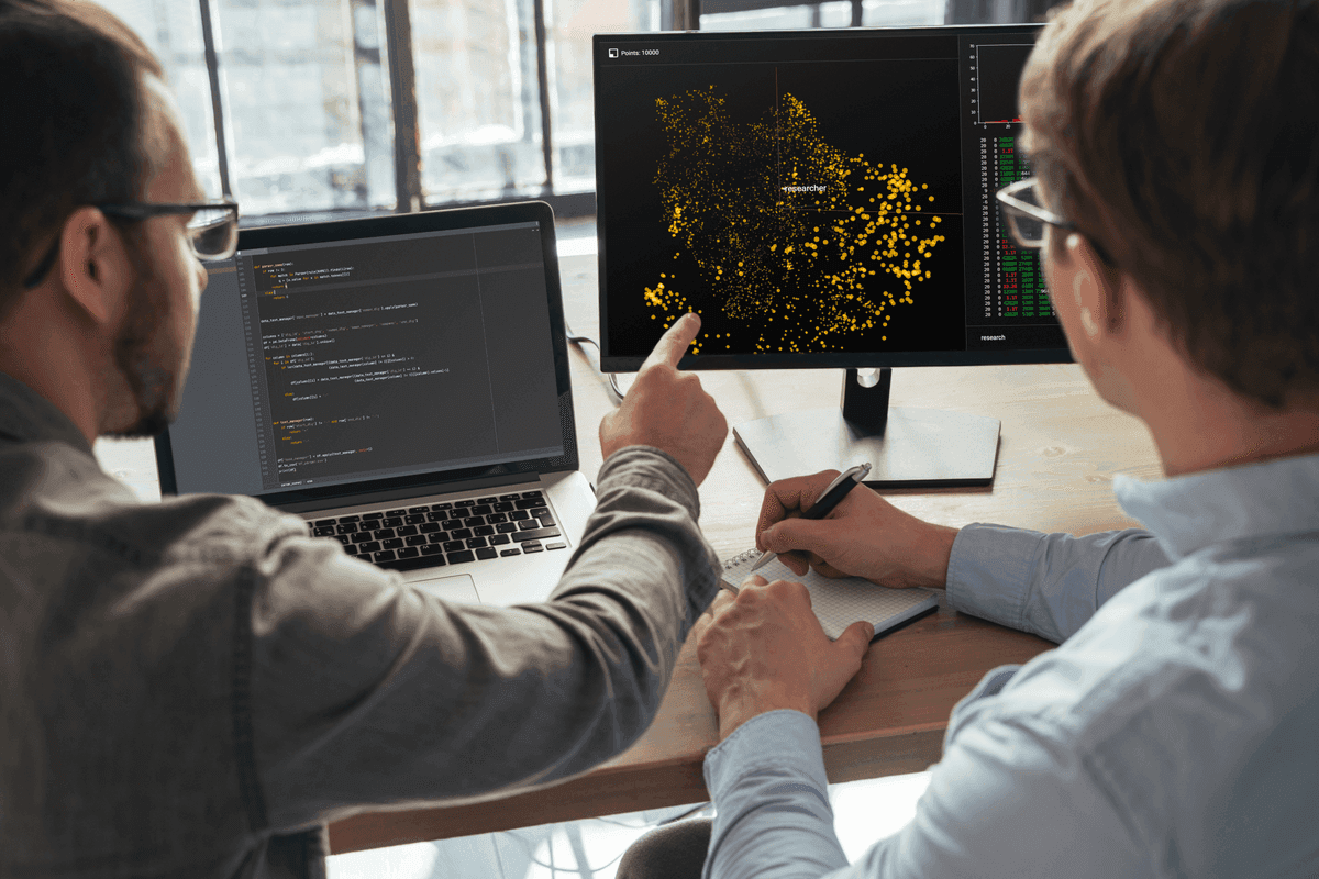 Dois profissionais analisando dashboards de monitoramento SolarWinds em um monitor.